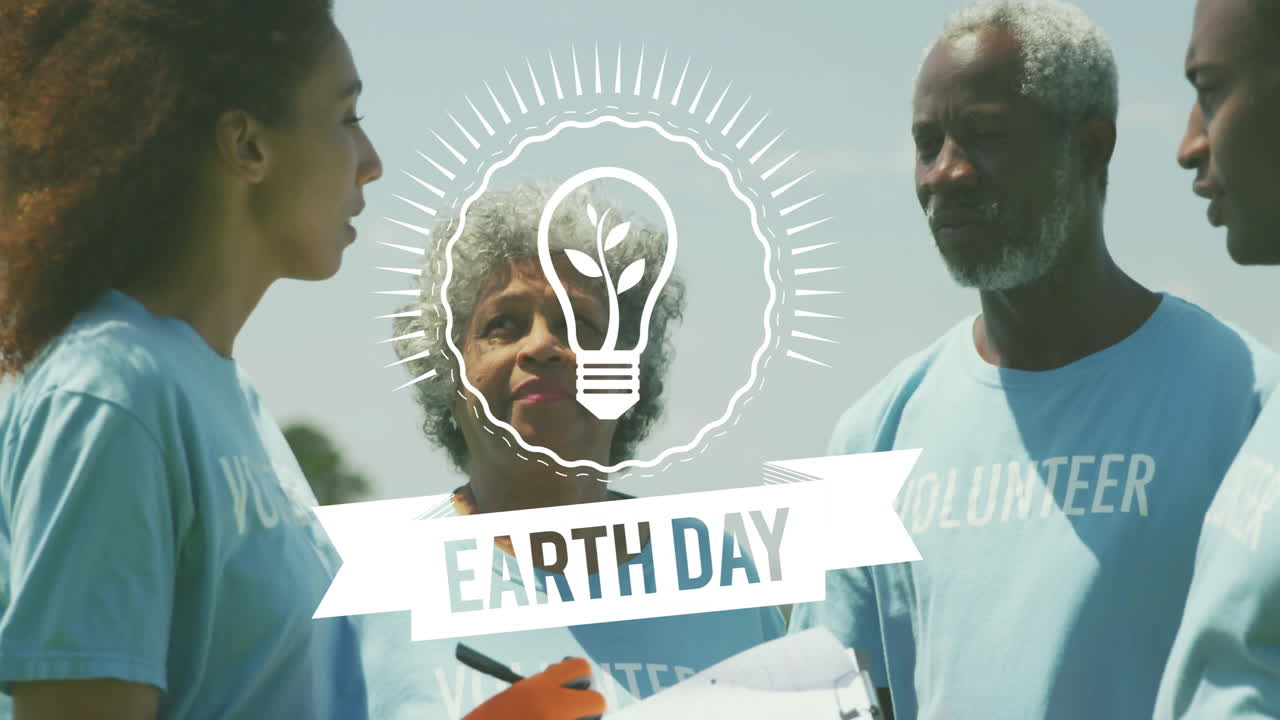 Earth Day light bulb animation over volunteers discussing environmental project outdoors
