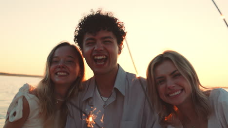 friends celebrating at sunset beach with sparkler