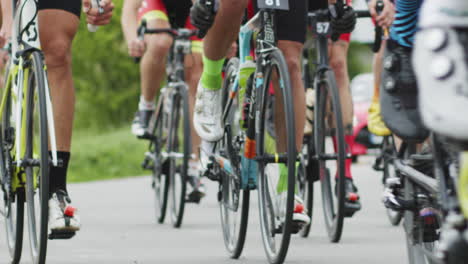 Shallow focus shot of cyclists lower bodies while riding bikes in cycling race the bicycle wheel is
