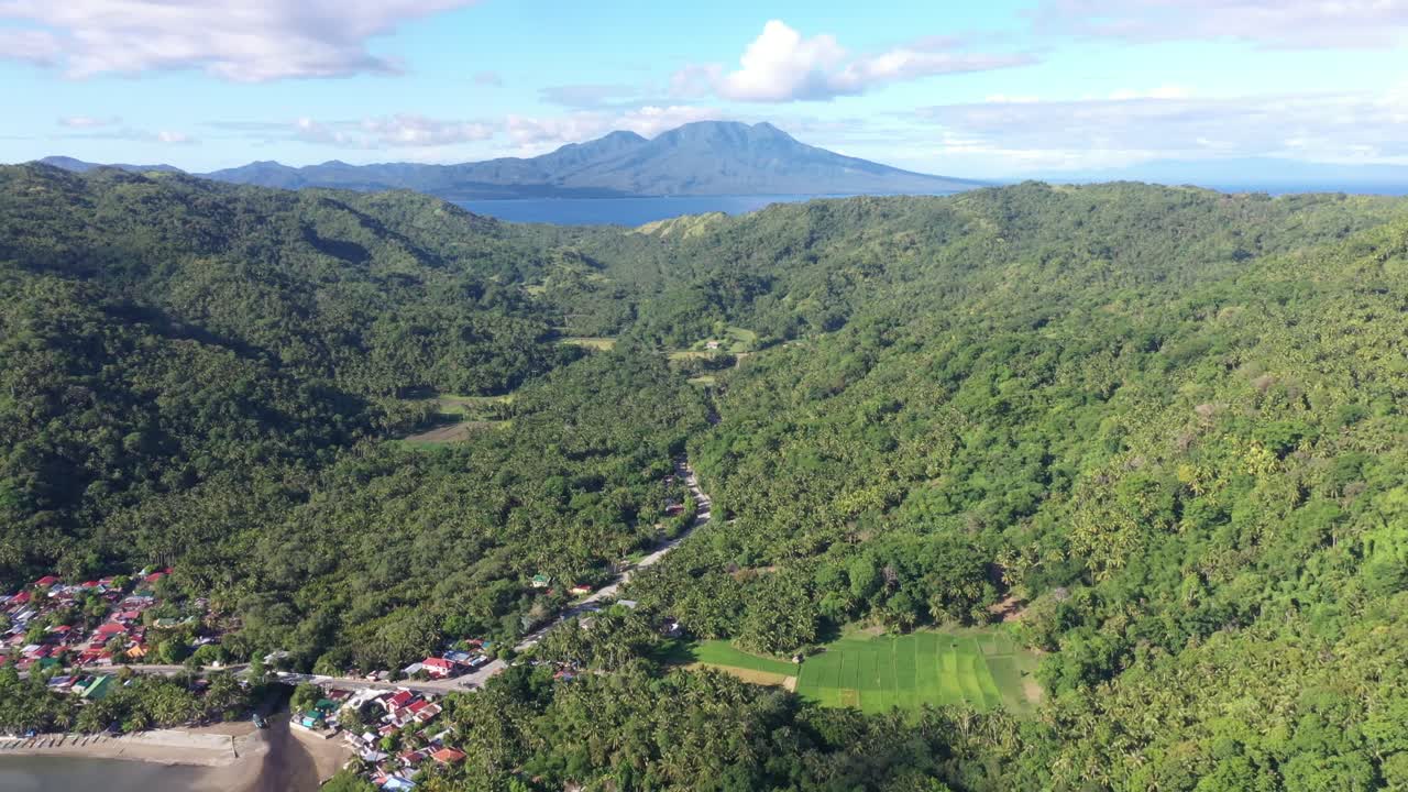 필리핀에서 여름 동안 섬에 있는 녹색 산과 마을의 파노라마