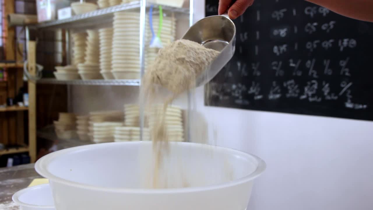 scoop of flour gently poured in a bowl, close