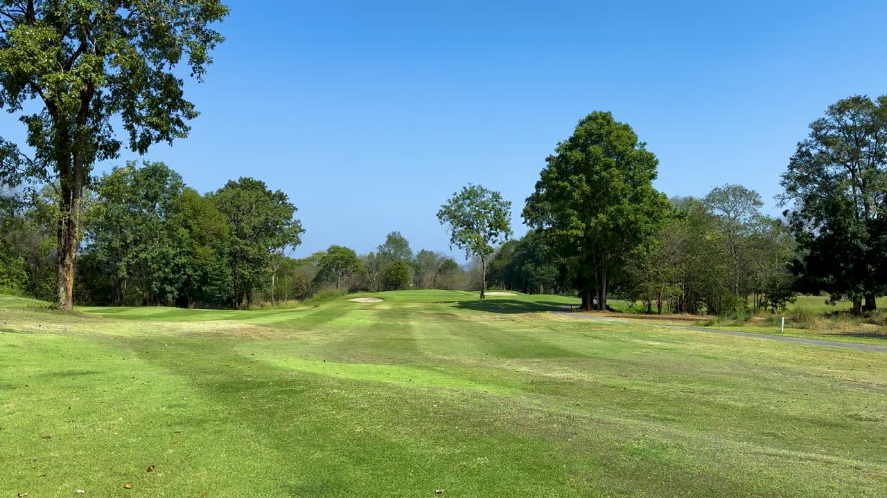Lush green fairway with surrounding trees