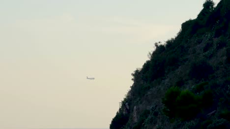 airplane flying into airport during sunset
