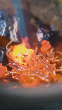 cu shot: melting of old gold accessories in fireproof cup with hot gas burner on table with asbestos sheet in workshop closeup