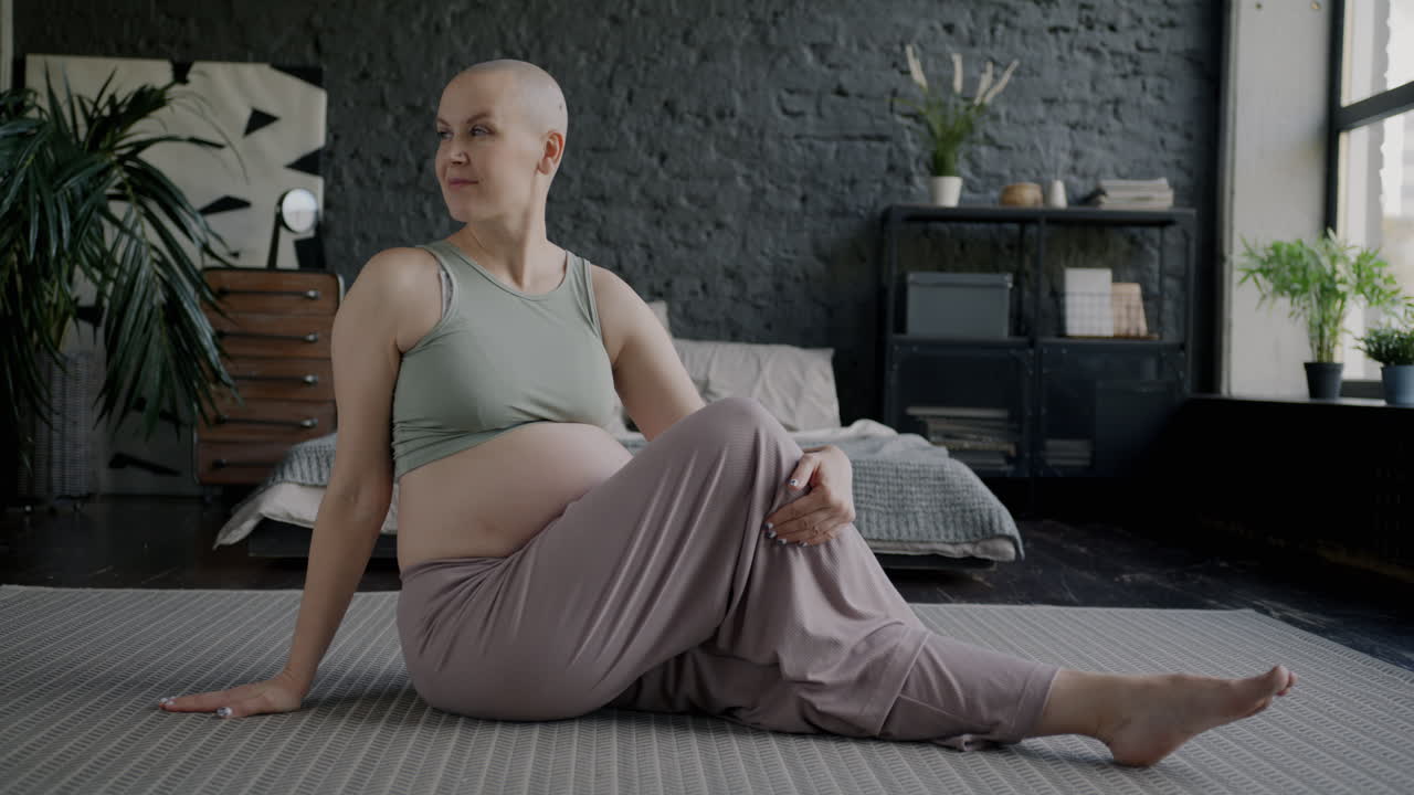 Pregnant woman practicing yoga in her bedroom
