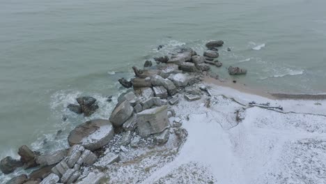 Aerial-birdseye-view-of-abandoned-seaside-fortification-buildings-at-Karosta-Northern-Forts-on-the-beach-of-Baltic-sea-,-overcast-winter-day,-drone-shot-moving-forward