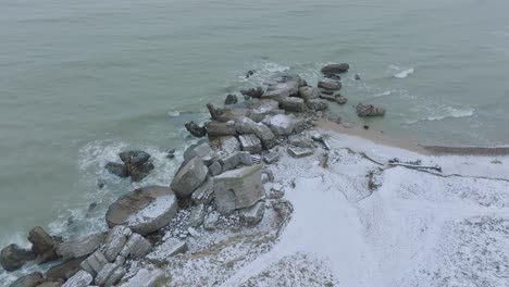 vista aérea de los edificios de fortificación costeros abandonados en los fuertes del norte de karosta en la playa del mar báltico, día de invierno nublado, tiro de drones avanzando