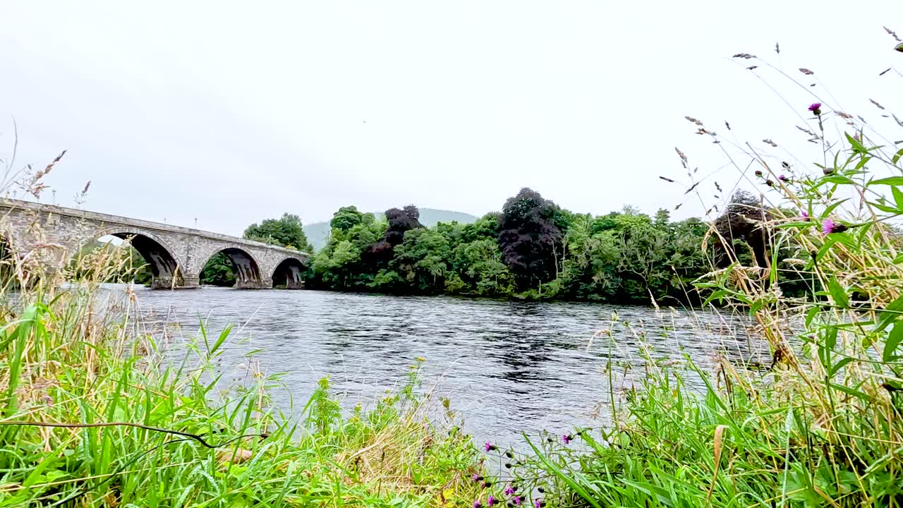 역사적인 돌 다리와 함께 평화로운 강 풍경