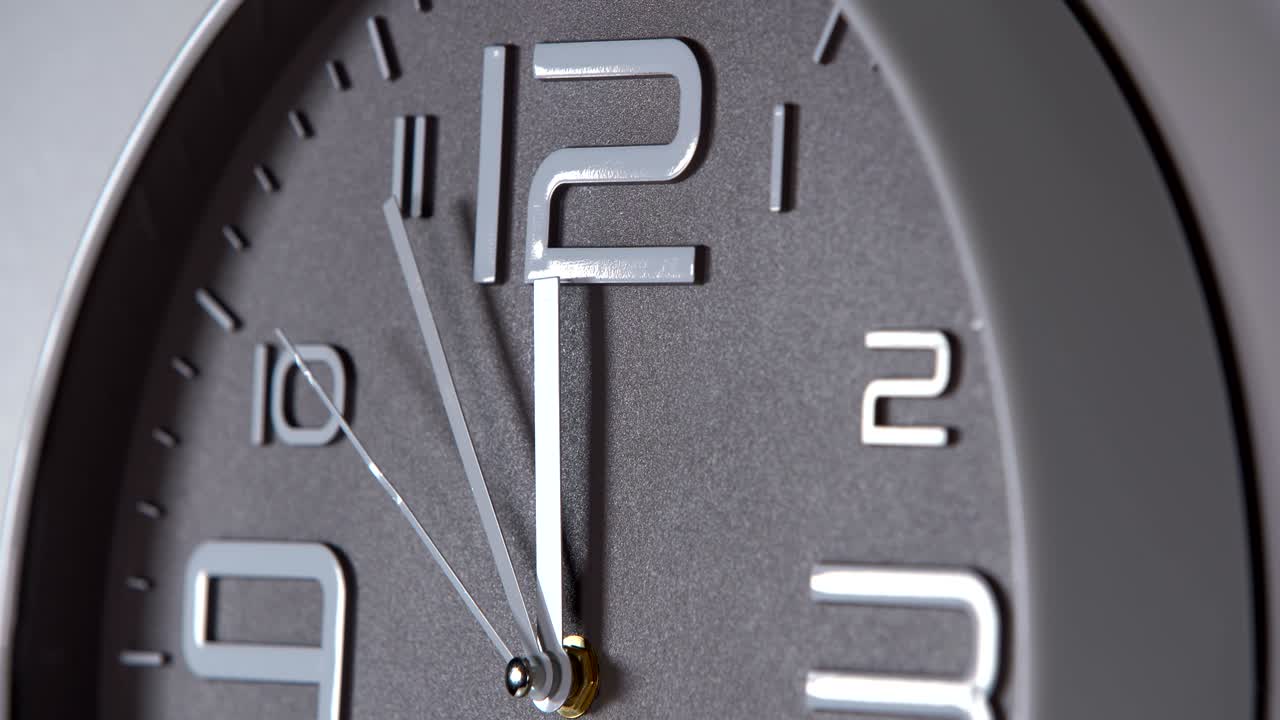 reloj de pared en un fondo gris. 23:55