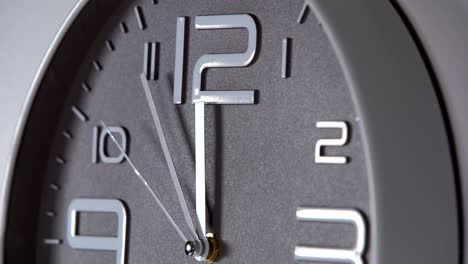 reloj de pared en un fondo gris. 23:55