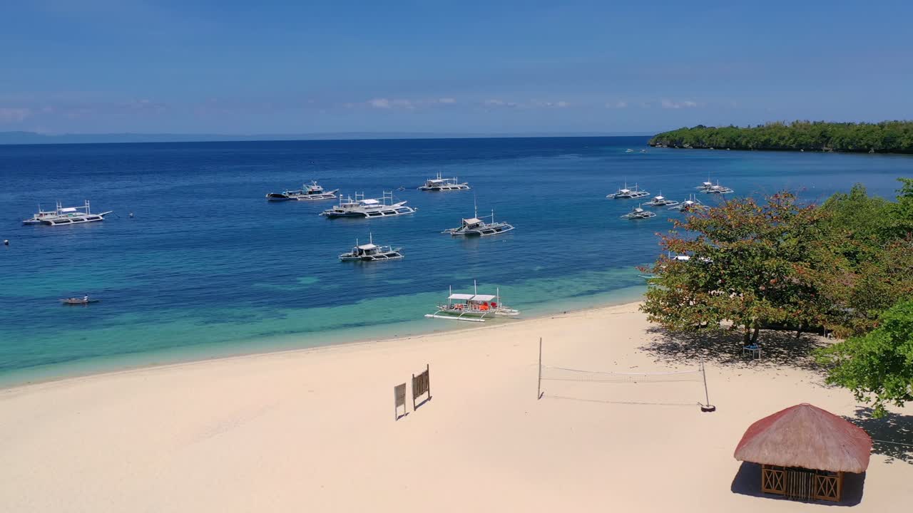 Idilliaca spiaggia tropicale con sabbia dorata e bangka su acqua cristallina