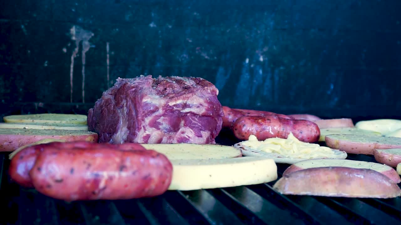 en primer plano, carne a la parrilla con chorizos, tortillas de queso, frijoles guatemaltecos y patatas asadas fumando y preparación jugosa lista para comer en familia en un día de la temporada de verano [hd1920 x 1080] fps 29