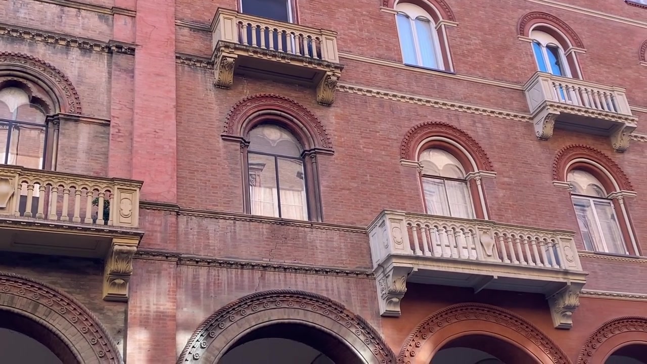 Facciata di un palazzo storico con balconi ornati e portici a Bologna, Italia