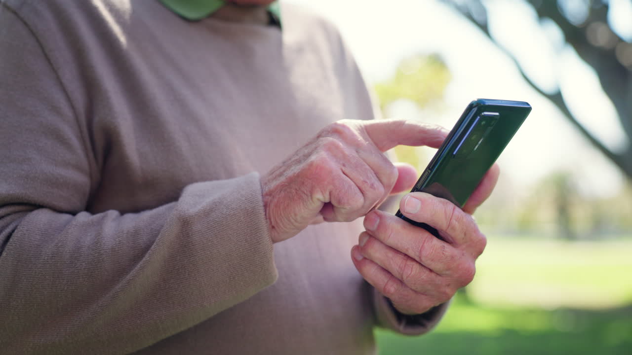 hombre mayor, manos y usando el teléfono al aire libre en el parque