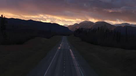 sunset casts golden light over alaska highway and mountains