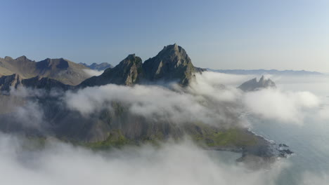 Drone-aerial-footage-of-Coastal-mountains-and-cliffs-at-Stokkness-at-sunrise-with-beautiful-layer-of-clouds-in-Iceland