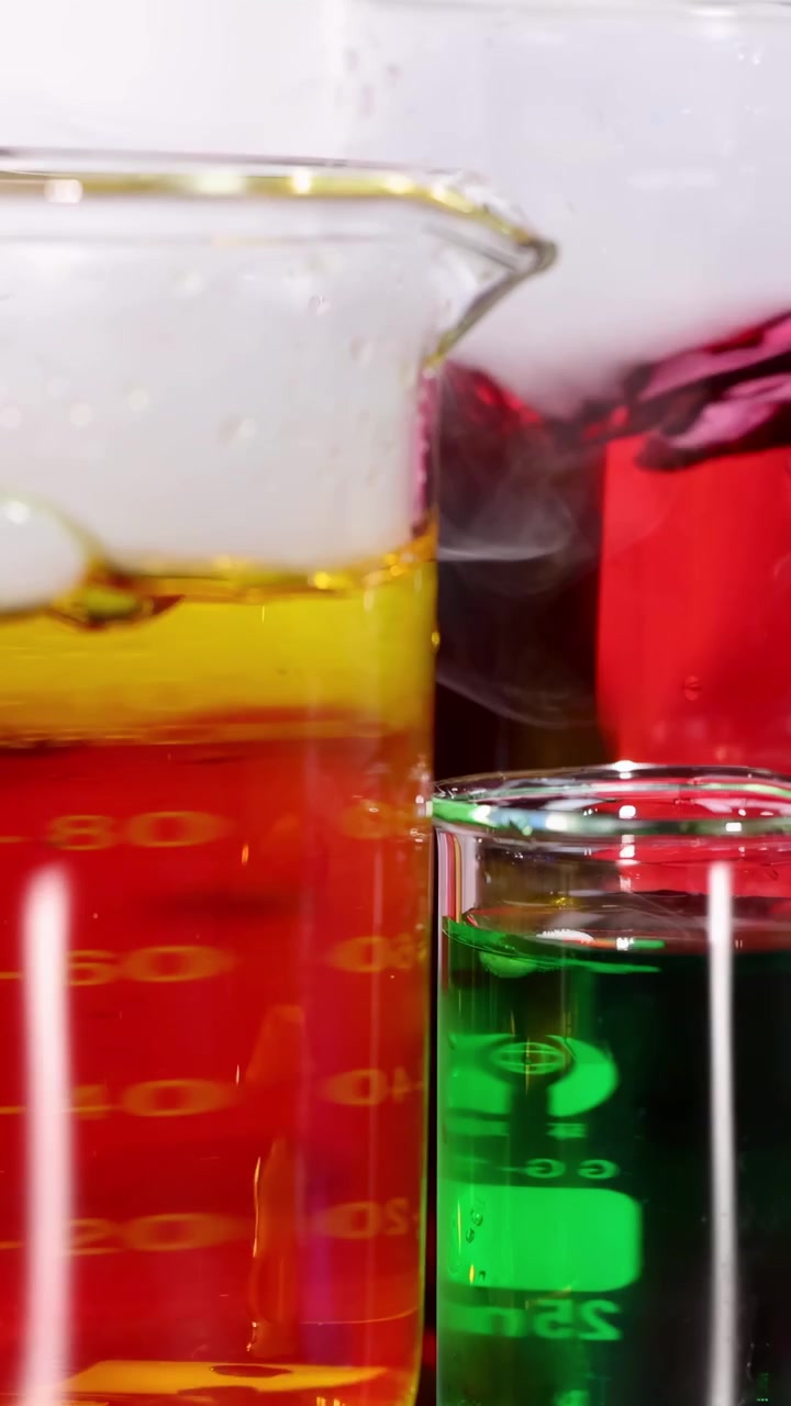 Becher con liquidi colorati e reazione con ghiaccio secco