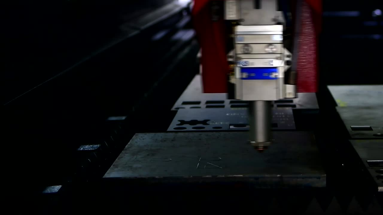 Industrial laser cut machine while cutting the sheet metal with the sparking light.