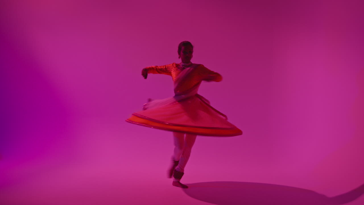 Film Or Video Studio Recording Female Kathak Dancer Wearing Traditional Indian Dress Spinning During Performance