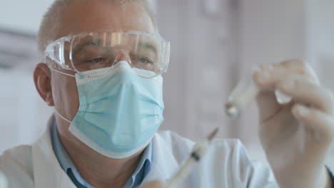 el médico dibuja la vacuna en el frasco de la jeringa para la inyección de la ampolla de coronavirus de covid-19. fotografía de cerca de una enfermera o médico irreconocible con guantes llenando la jeringa de la ampulla con vacuna contra covid-19. imágenes de alta calidad en 4k