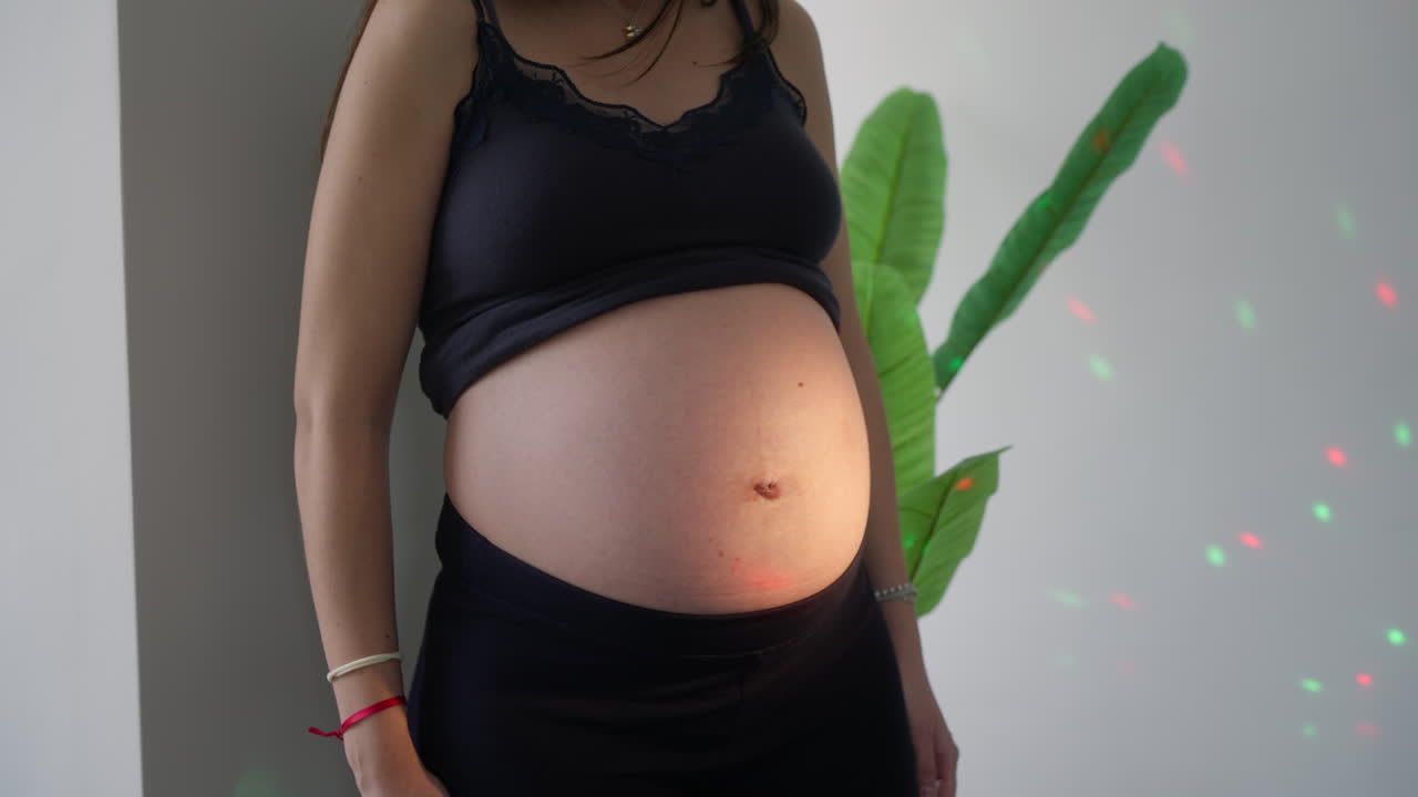 Expectant Mother's Belly Illuminated by Colorful Lights