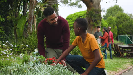 family gardening together outdoors, father and son enjoying planting flowers