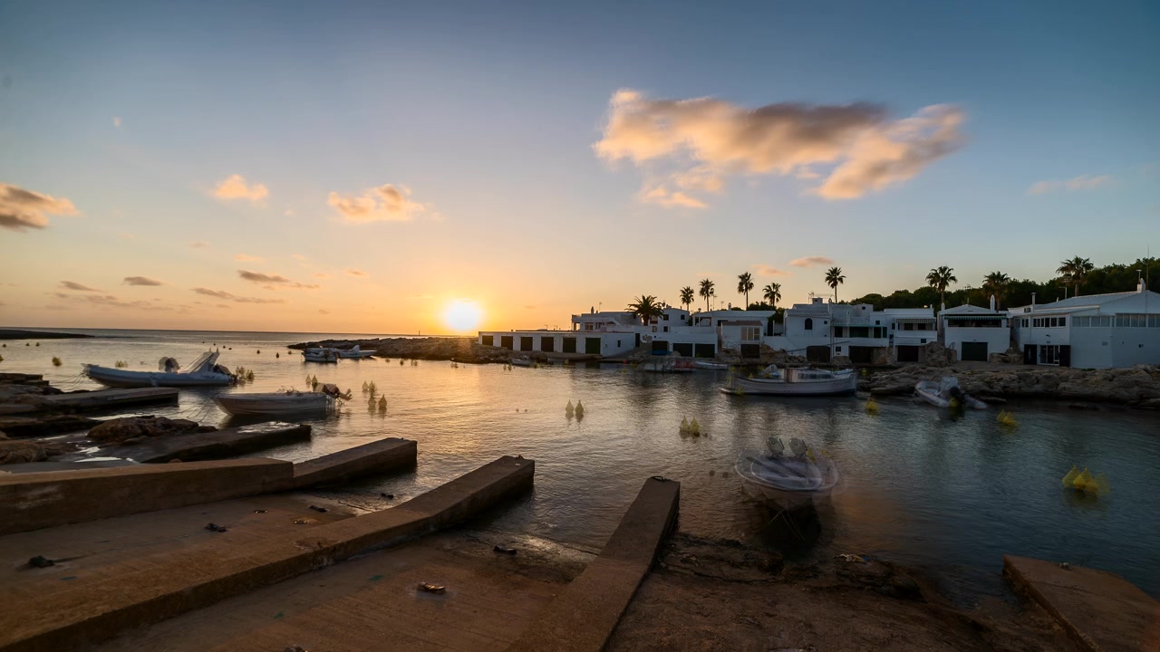 Thuyền neo đậu tại cảng ở làng nhỏ Biniancolla-Punta Prima lúc hoàng hôn ở Menorca, Tây Ban Nha. Timelapse