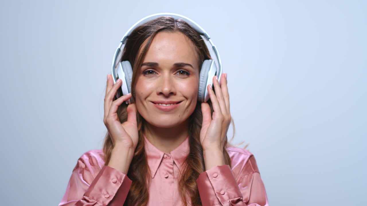 mujer de negocios poniendo auriculares en el estudio. chica disfrutando de la música en los auriculares
