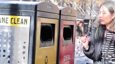 individual throws trash into bin