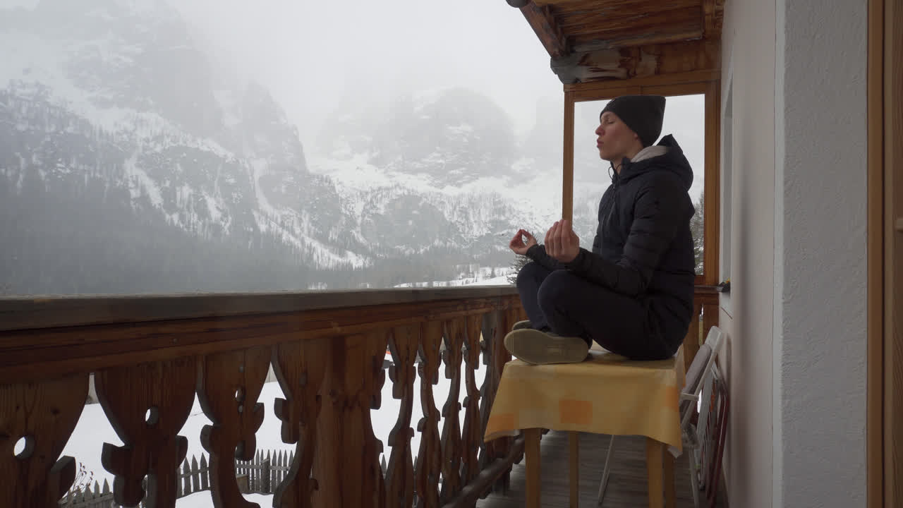 un italiano meditando en un balcón con una vista enorme de las montañas dolomitas durante el invierno en italia