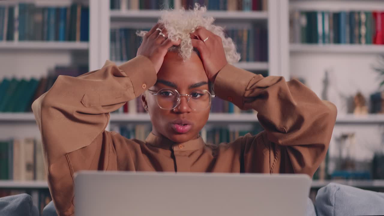 African american woman holding head in hands feeling shocked about bad news