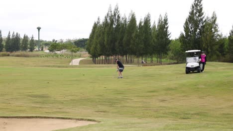 person driving a golf cart across a course