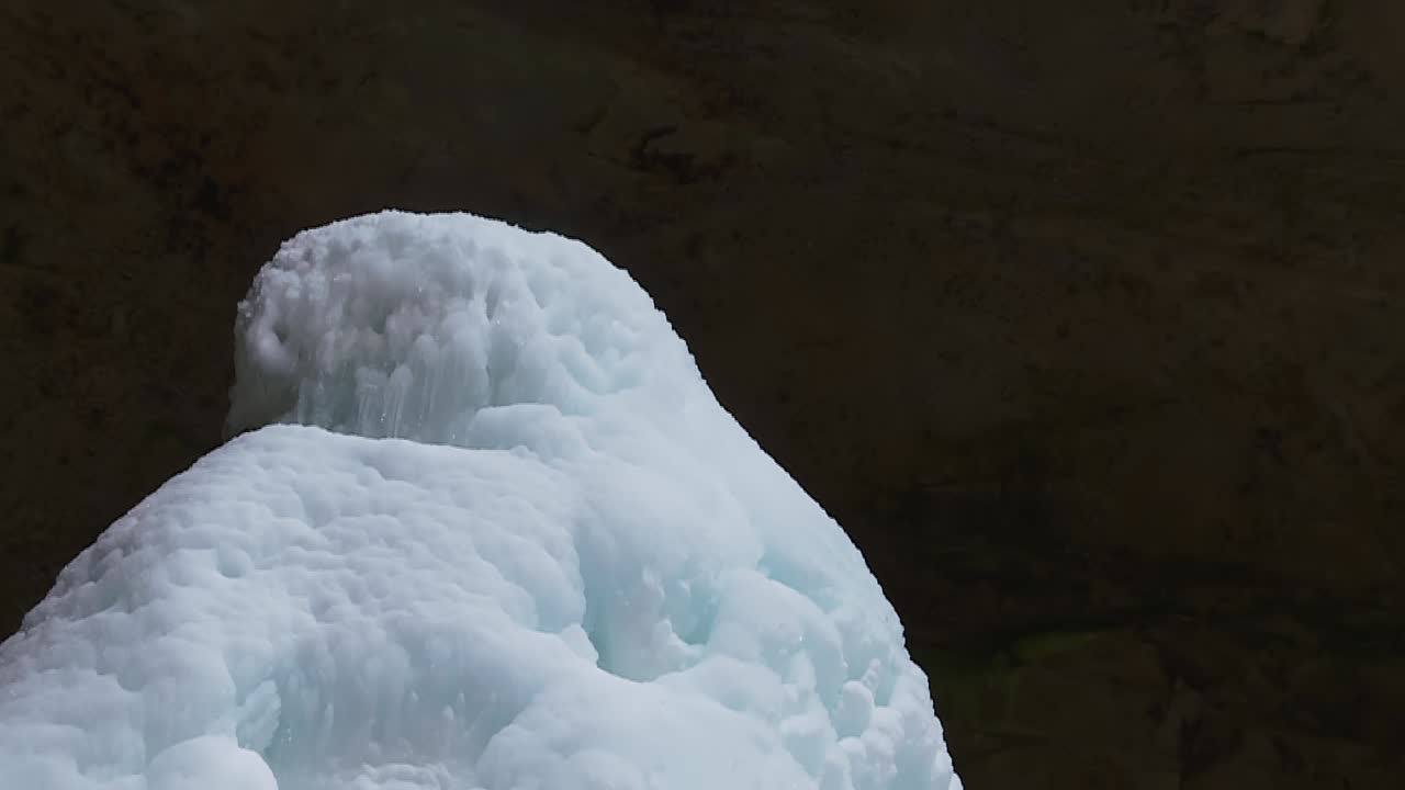 오하이오 주 사우스 블루밍빌 호킹 힐스 주립공원의 겨울에 얼음 원뿔이 있는 화산재 동굴 절벽에 고드름이 매달려 있습니다.