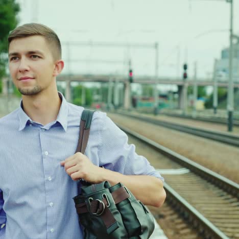 a good-looking young businessman walks along the railway platform 2