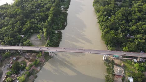 bridge with traffic over brown color river in bangladesh, aerial drone view