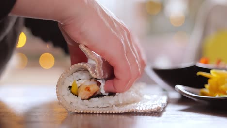 making sushi at home kitchen. woman hands rolling homemade sushi.