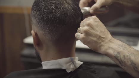 men's hair is trimmed with razor shaving machine at the barber shop