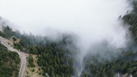 flying towards foggy valley over mountain road in heart of bucegi mountains, romania