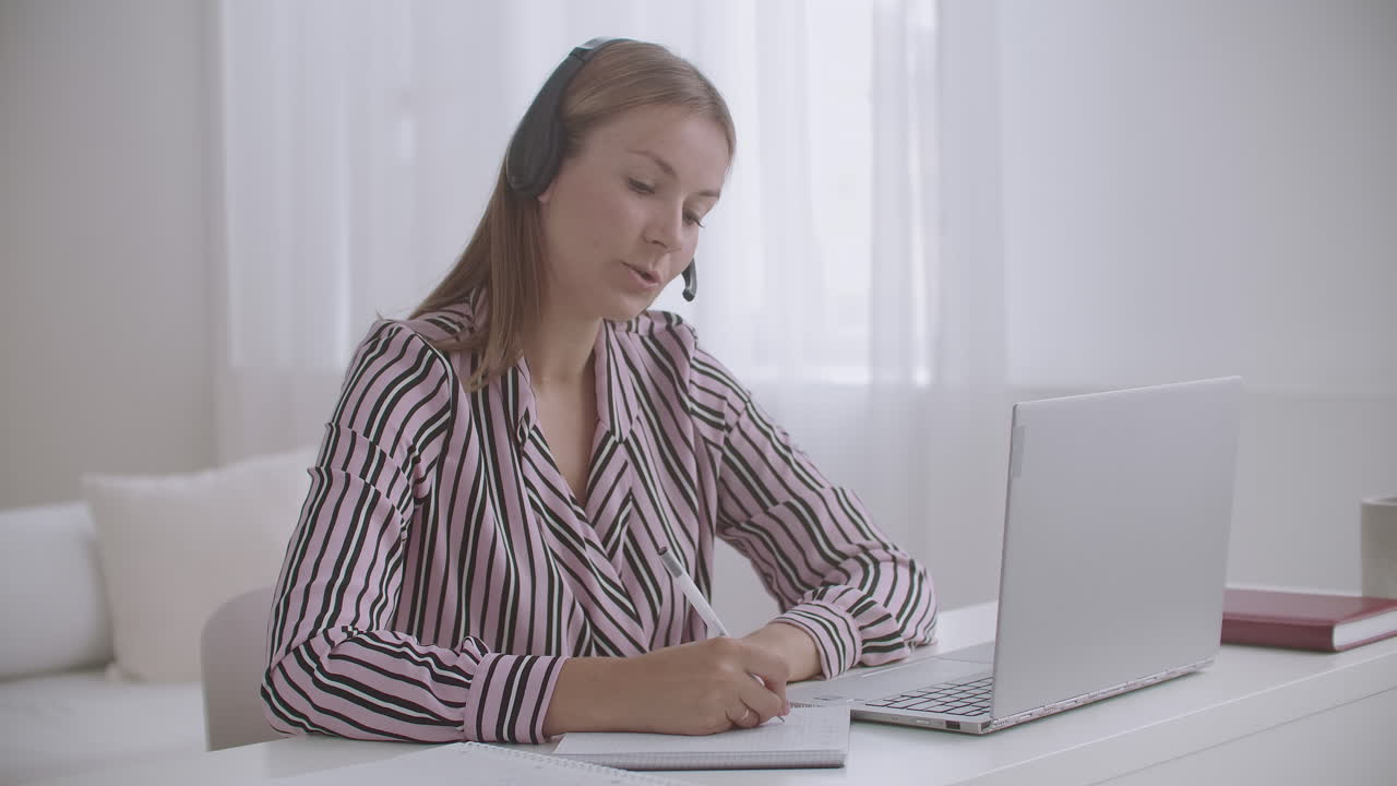 una joven maestra está hablando por videochat con alumnos que enseñan en línea en la pandemia de coronavirus