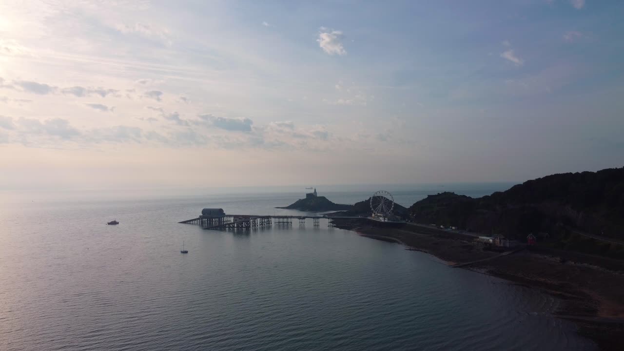 Veduta aerea del Mumbles Pier e del faro all'alba. Luce mattutina dorata sulla baia. Perfetto per il turismo, documentari di viaggio. Galles, Regno Unito. 4K.