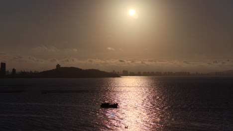 Amazing sunset shot from the Atlantic Ocean with distant view of Penha municipality and Balneario Picarras, Santa Catarina, Brazil