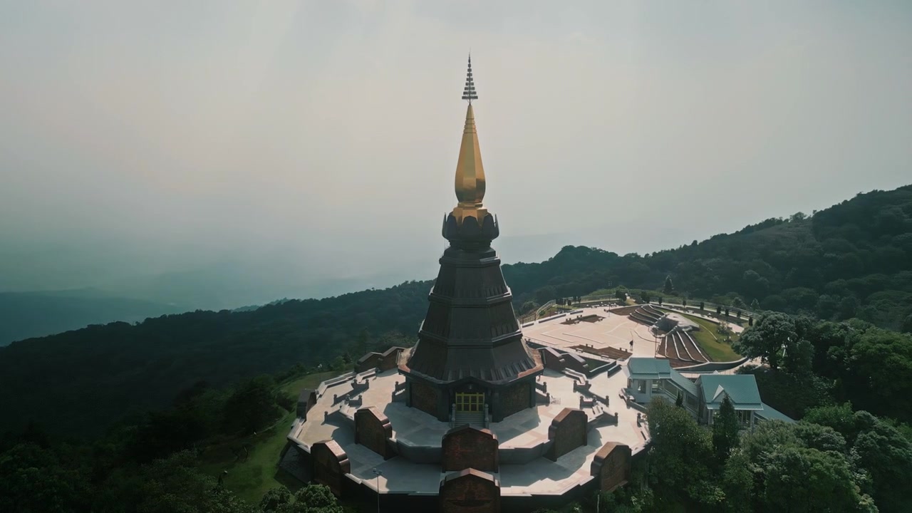 Majestuosa pagoda budista con aguja dorada en la cima de una montaña