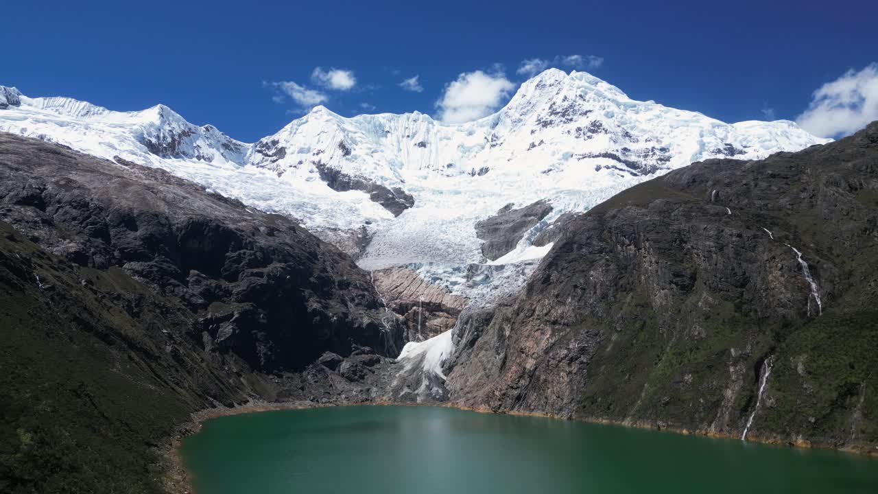 Thin waterfalls cascade into Laguna Rajucolta from Huantsan mountain
