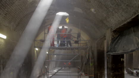 les travailleurs qui mettent au rebut une surface de plafond dans un ancien réservoir d'eau