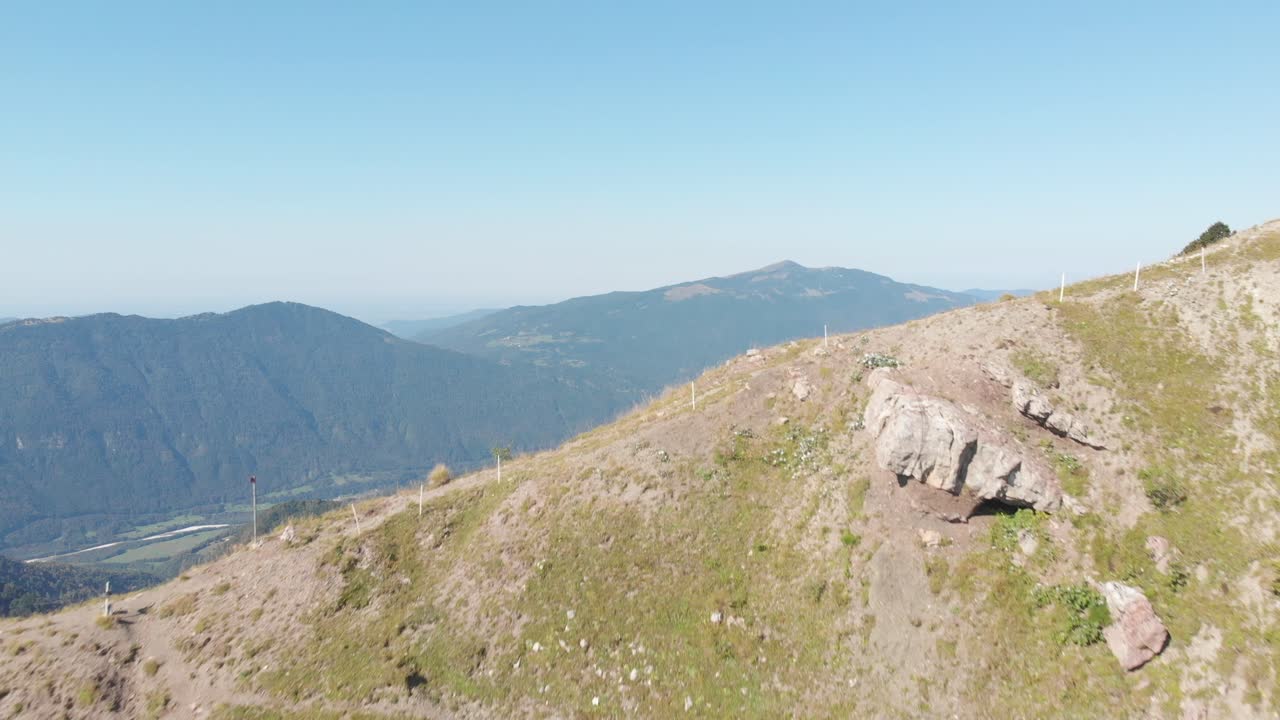 drone vuela sobre la cima de la montaña revelando un paisaje cultivado con pastos
