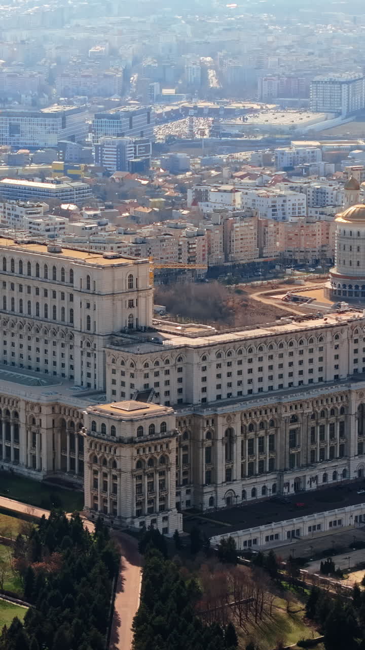 Vertical aerial drone view of Palace of the Parliament in Bucharest downtown in sunlight. Romania