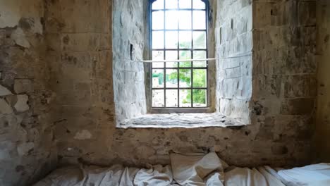 a bed in an old room with a window in it