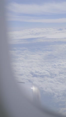 clouds viewed from an airplane window with the wing visible in the shot
