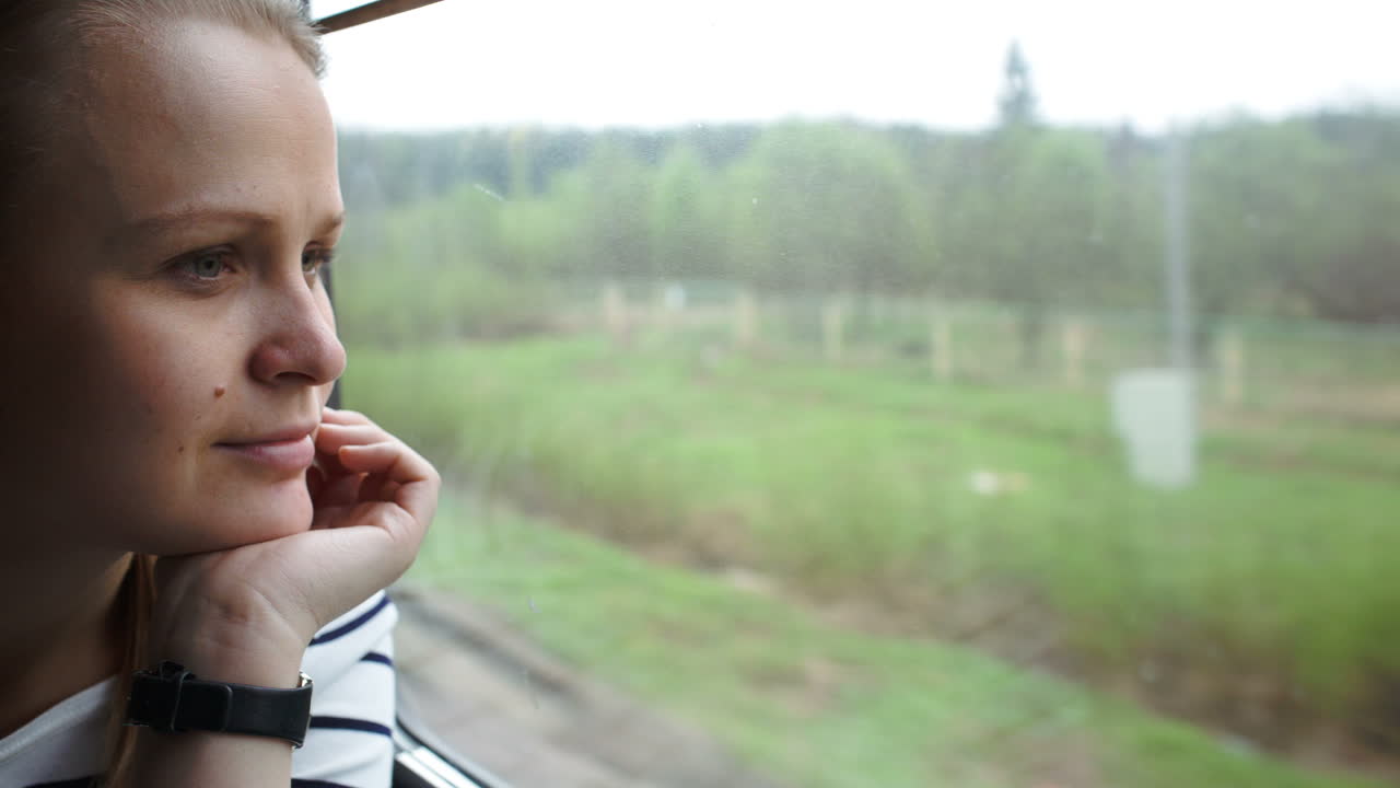 Young woman looking out the window of moving train