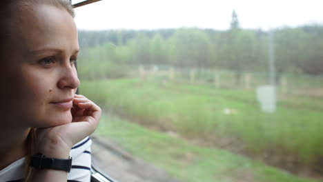 young woman looking out the window of moving train